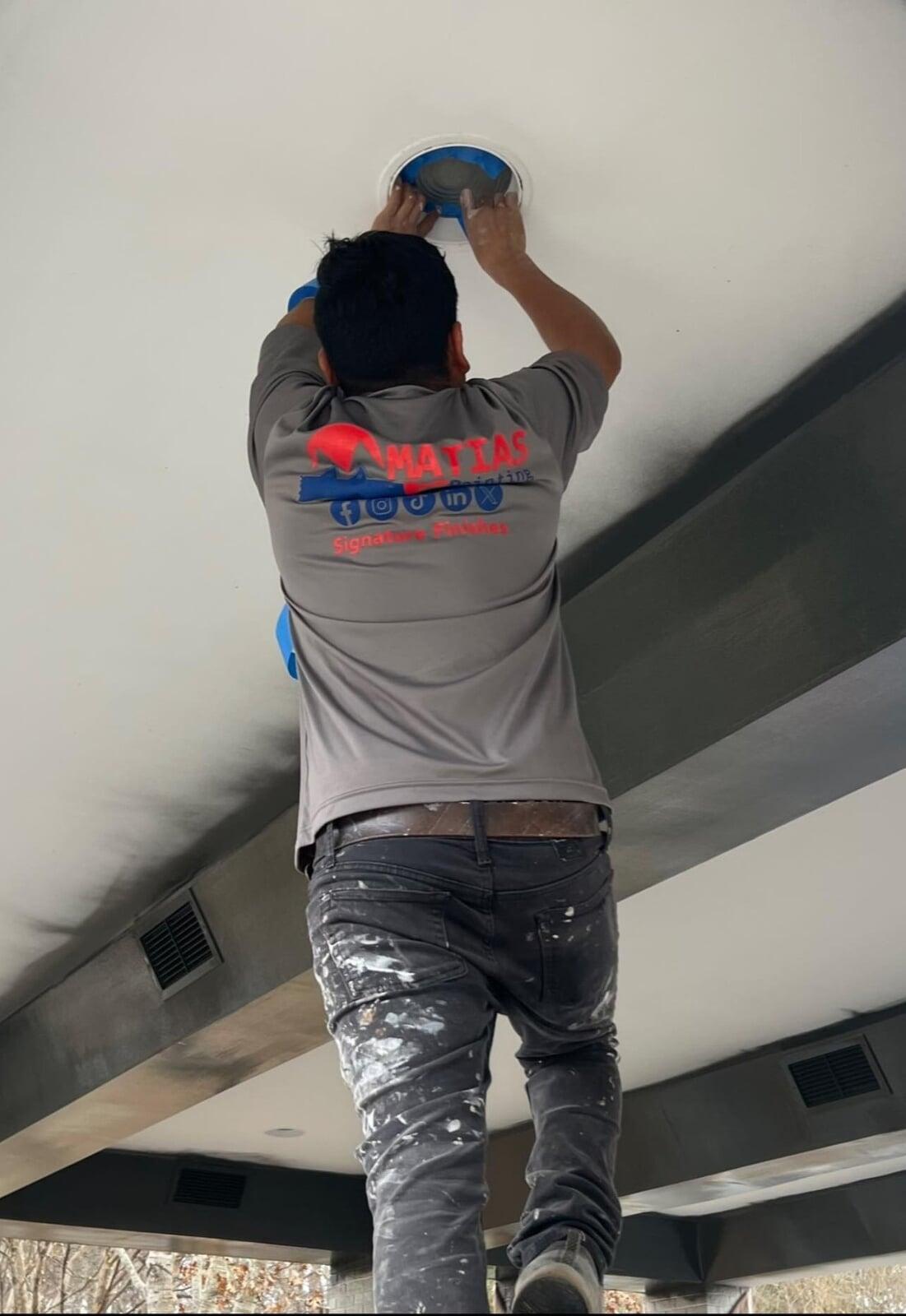 Professional painter at work, highlighting Matias Painting LLC as a locally owned Raleigh business